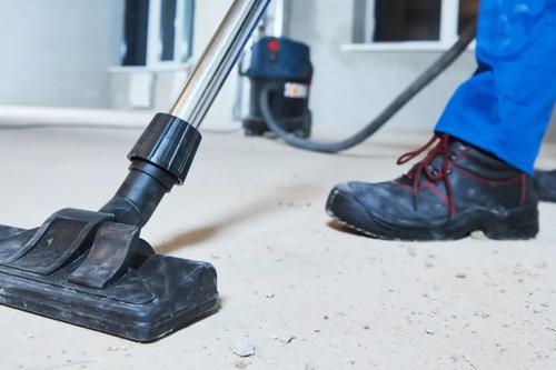 Baustaub wird mit einem Industriesauger vom Boden gesaugt
