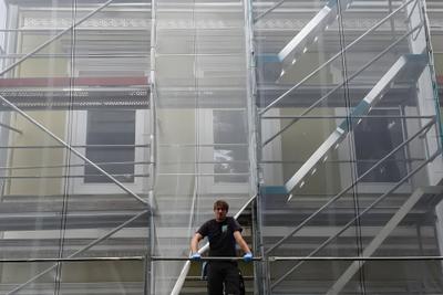 Mitarbeiter auf einem Gerüst vor einer Hausfassade