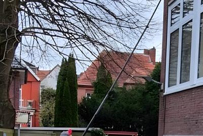 Fensterreinigung mit Teleskopstange an einem Wohnhaus